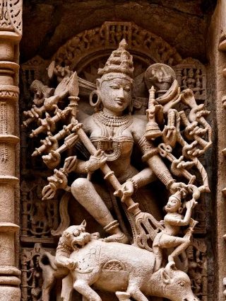 Perhaps the most intricate and well preserved Mahishasurmardini in India is this carving from the Ran-ki-Vav stepwell in Patan, Gujarat. The step well, constructed in the 11th century by Solanki Queen Udayamati, was designated by UNESCO as a World Heritage Site in 2014. The construction of step wells, called vav (also wav) or baoli in western India, formed a very important part of royal projects and philanthropy, in providing drinking water to citizens and along trade routes. These wells also offered a place for rest and prayers. In Hinduism, water has always been considered sacred, therefore step wells were constructed like inverted temples with a profusion of sculptures of gods and goddesses from the brahmanical pantheon and stories from the Hindu epics. This Mahishasurmardini is notable for the deep carving, making the statue almost three dimensional. Durga is holding Mahishasura by his hair as he emerges from the decapitated buffalo.